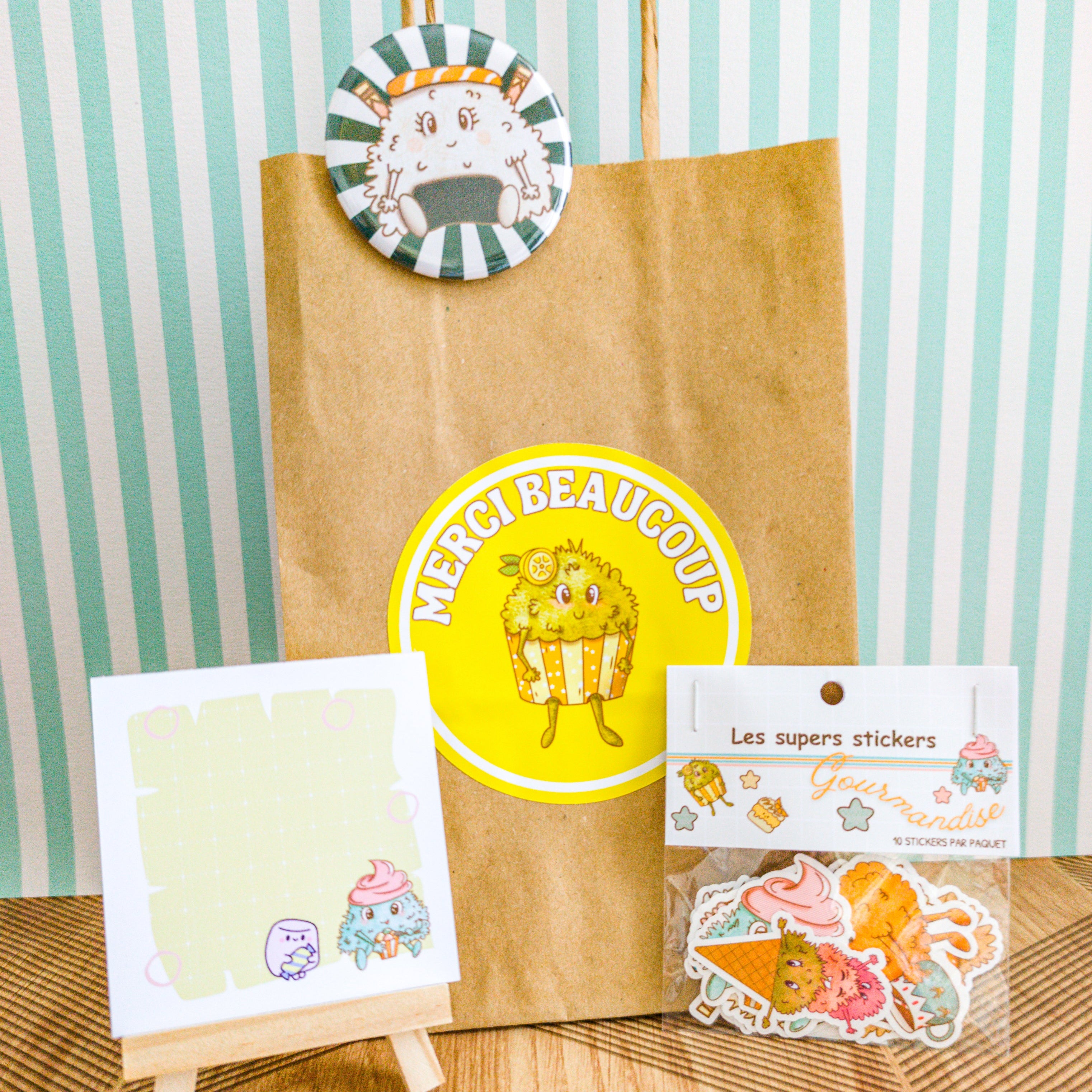 Présentation du sachet avec son bloc-note, son sachet de stickers et son badge.