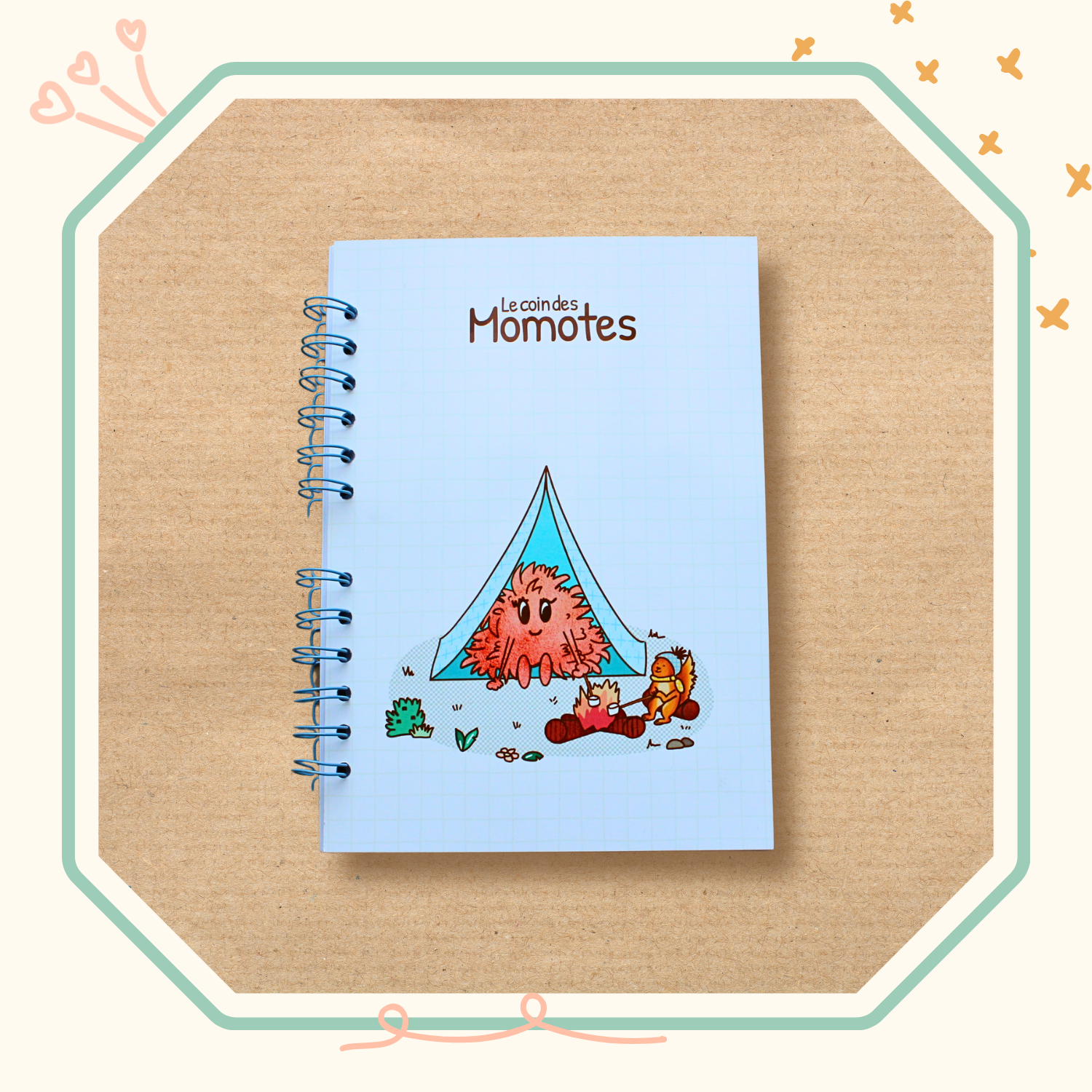 Visuel d'un cahier spirale avec une momote qui fait du camping avec un écureuil.
