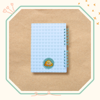 Dos de couverture cahier spirale avec des cœurs verts et une momote logo.