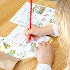 Photo d'une enfant qui remplit un bon de livraison lors d'une session de jeu d'imitation à la fleuriste.