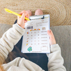 Photo d'une enfant qui remplit une ordonnance du kit de papeterie pour jouer au médecin.