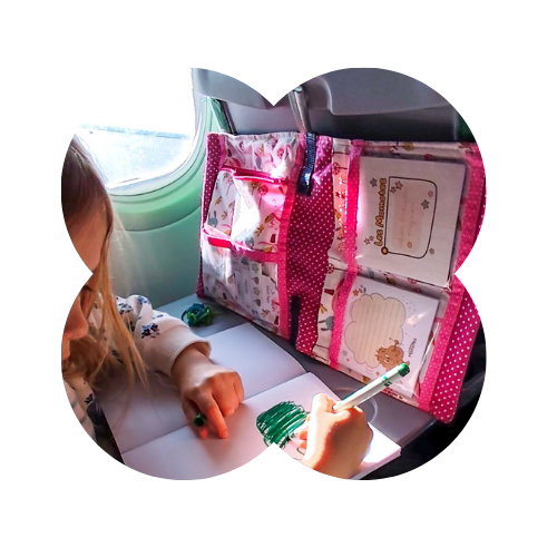 Enfant qui utilise la sacoche d'activités pour s'occuper durant un voyage en avion.