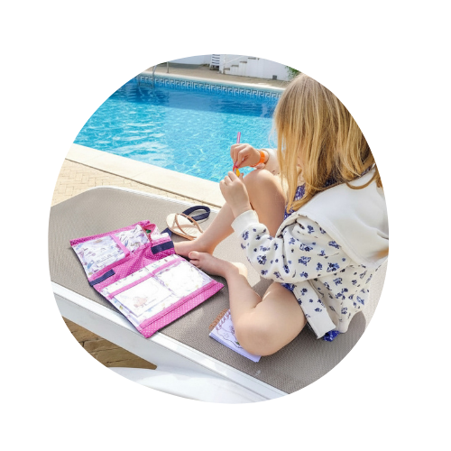 Enfant qui s'occupe avec la sacoche d'activités au bord d'une piscine pendant les vacances.